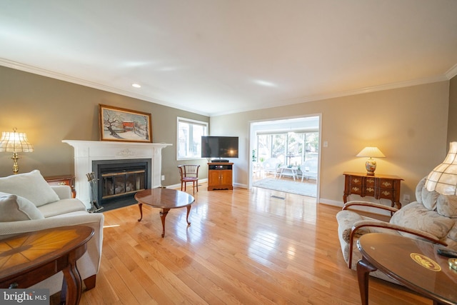 living area with a fireplace with flush hearth, light wood-style flooring, crown molding, and baseboards