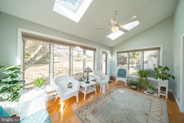 sunroom featuring vaulted ceiling with skylight, plenty of natural light, and a ceiling fan