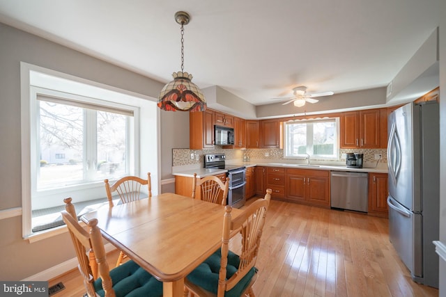 dining area with visible vents, baseboards, ceiling fan, and light wood finished floors