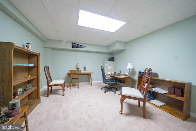 office space with concrete block wall, carpet flooring, a paneled ceiling, and visible vents