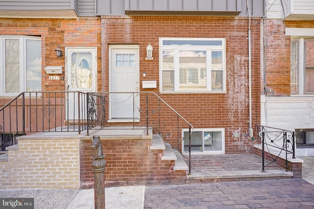 entrance to property with board and batten siding and brick siding