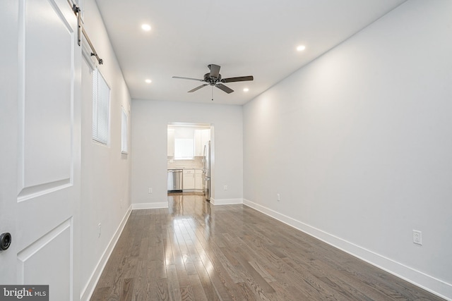 unfurnished living room featuring ceiling fan, dark wood-type flooring, recessed lighting, and baseboards