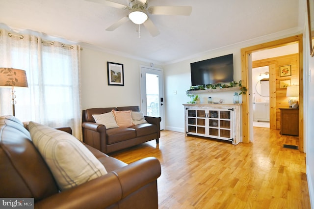 living area featuring visible vents, ornamental molding, ceiling fan, and wood finished floors