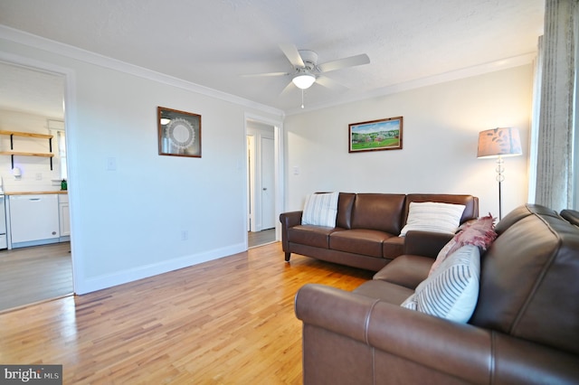 living area with baseboards, light wood-style flooring, a ceiling fan, and ornamental molding