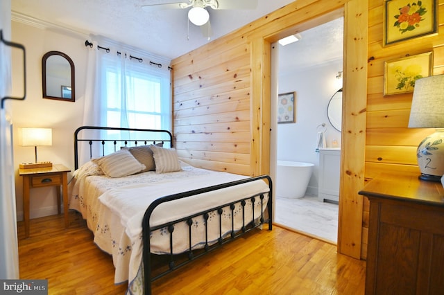 bedroom with wood walls, light wood-type flooring, and ceiling fan