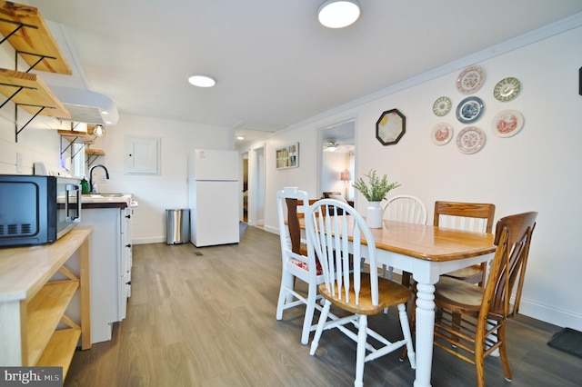 dining area featuring ornamental molding, baseboards, and wood finished floors