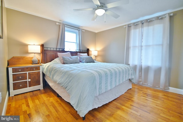 bedroom with a ceiling fan, crown molding, and light wood-style floors