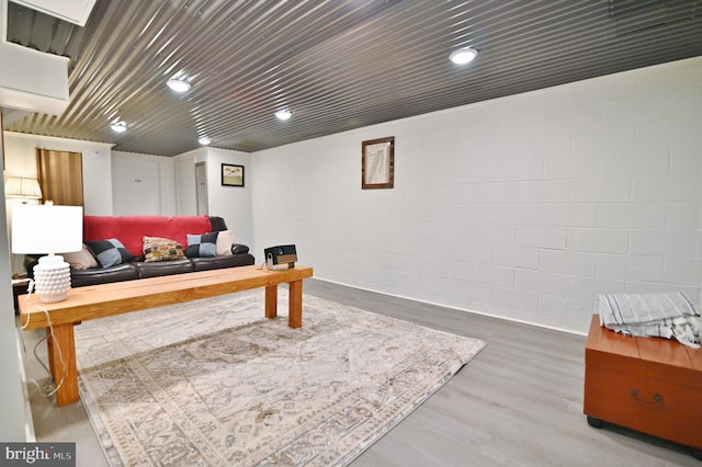 living room with concrete block wall and wood finished floors