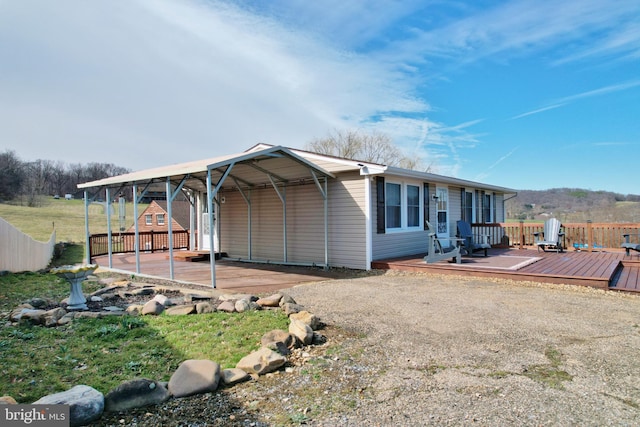 exterior space featuring a carport, driveway, and a wooden deck