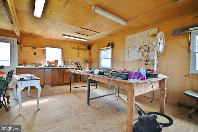 playroom featuring a workshop area, wooden ceiling, and wood walls