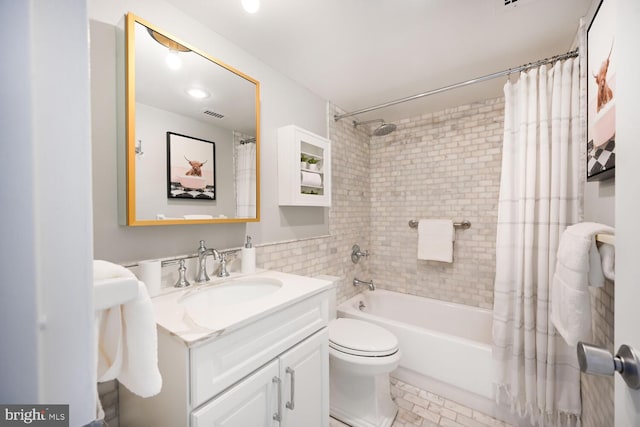 full bathroom featuring vanity, shower / tub combo, toilet, and visible vents