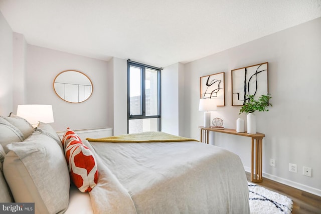 bedroom with baseboards and wood finished floors