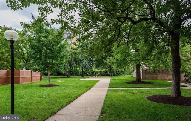 view of property's community featuring a yard and fence