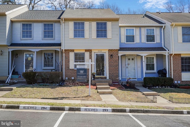 townhome / multi-family property with brick siding and a shingled roof