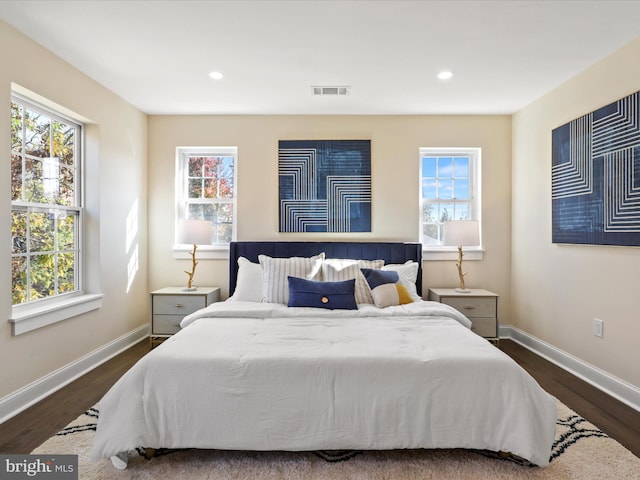 bedroom featuring multiple windows, visible vents, and baseboards