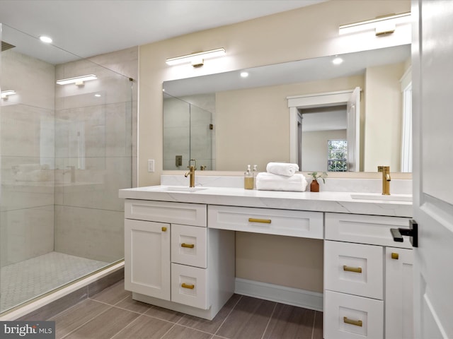 full bath featuring double vanity, a stall shower, and a sink