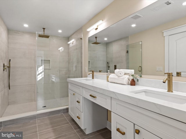 bathroom with a stall shower, visible vents, a sink, and double vanity