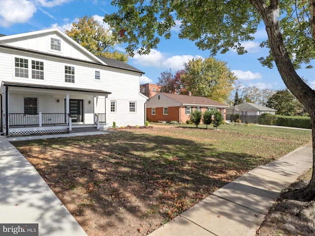 view of front of home with a front lawn, a porch, and board and batten siding