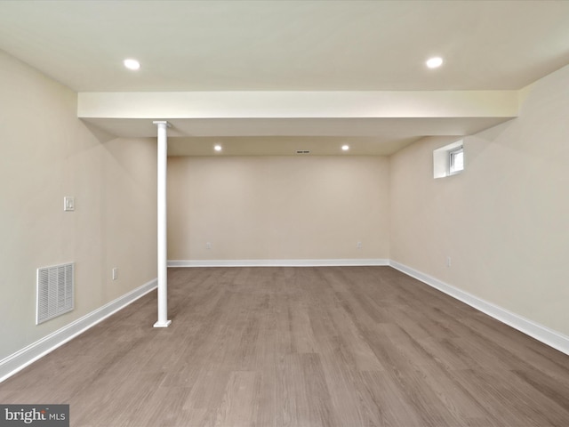 below grade area with baseboards, visible vents, wood finished floors, and recessed lighting