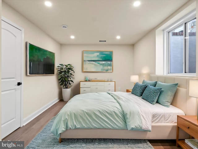 bedroom featuring baseboards, wood finished floors, and recessed lighting