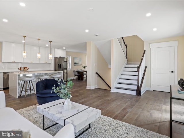 living room with baseboards, stairway, wood finished floors, and recessed lighting