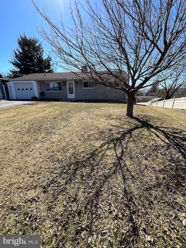 ranch-style home with a garage, a chimney, a front lawn, and fence