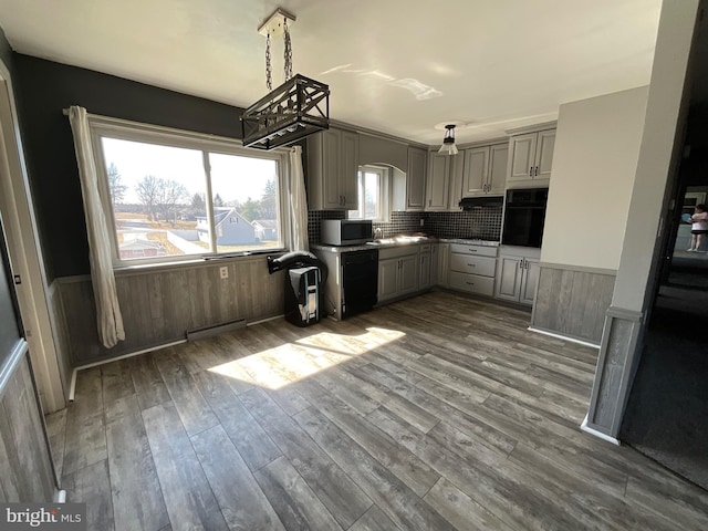 kitchen with visible vents, a wainscoted wall, dark wood-type flooring, black appliances, and gray cabinets