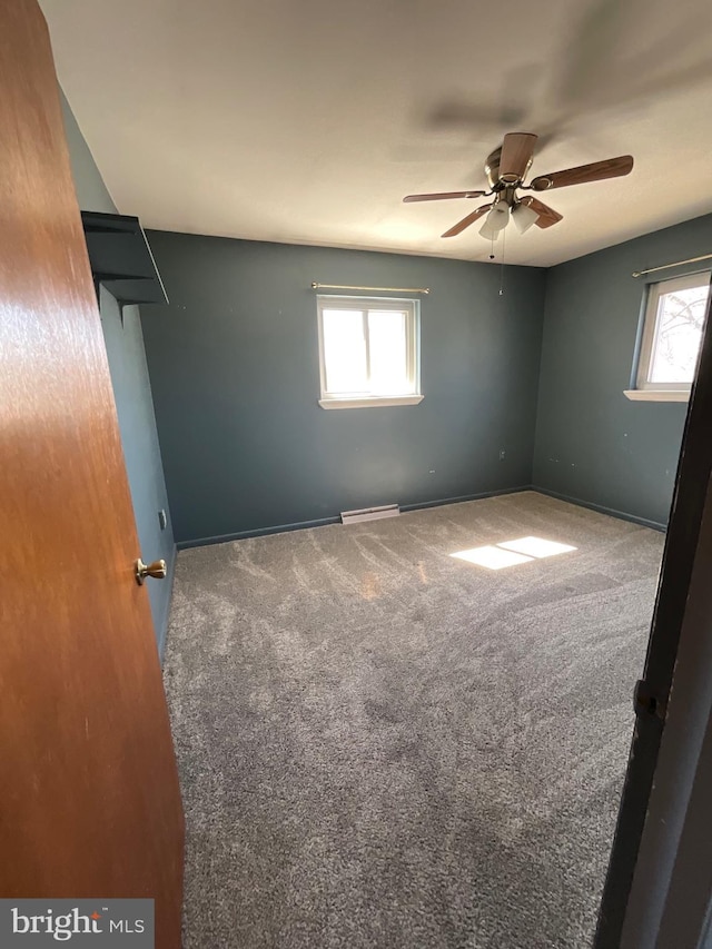 carpeted spare room featuring visible vents, baseboards, and ceiling fan