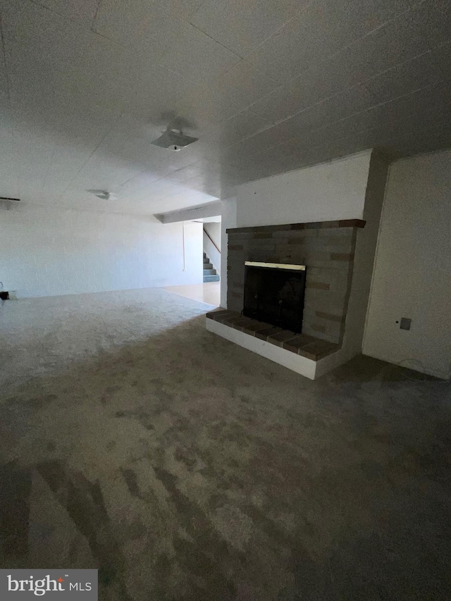 unfurnished living room with carpet and a fireplace