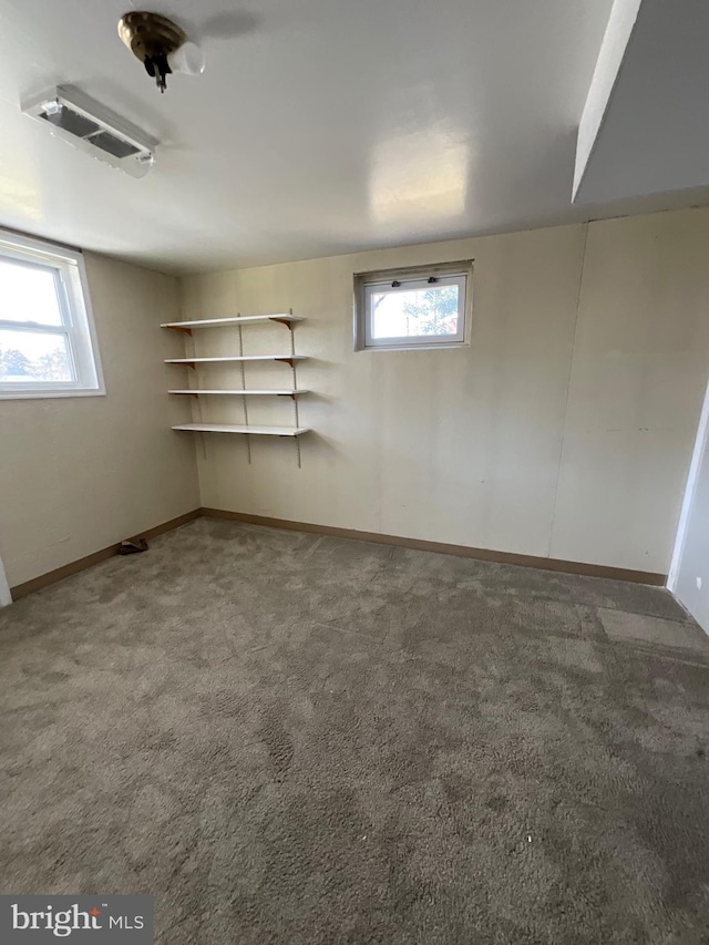 below grade area with baseboards, plenty of natural light, and carpet flooring