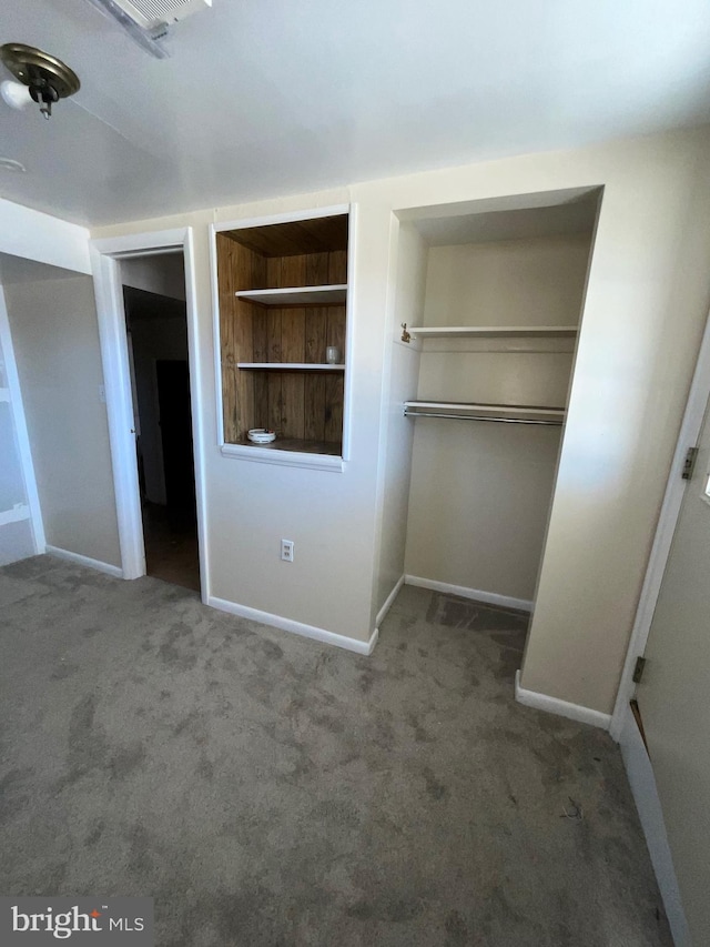 unfurnished bedroom featuring a closet, baseboards, and carpet floors