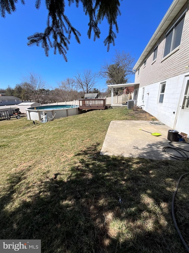 view of yard featuring an outdoor pool, central air condition unit, and a patio