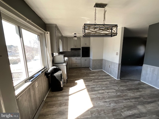 kitchen with dark wood-style floors, a wainscoted wall, gray cabinetry, and oven