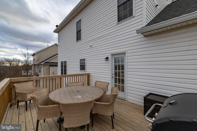 wooden terrace featuring outdoor dining area and grilling area