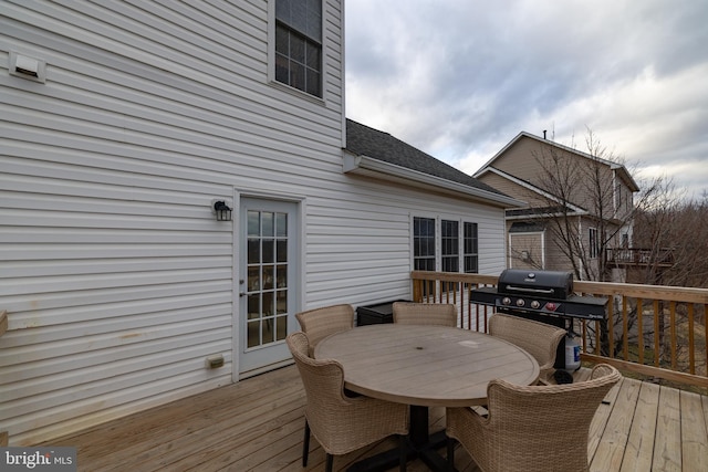 wooden terrace with outdoor dining area and area for grilling