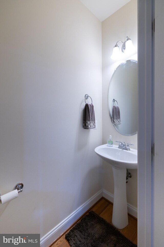 bathroom featuring a sink, baseboards, and wood finished floors