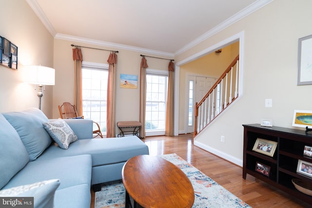 living room with ornamental molding, baseboards, stairway, and light wood finished floors