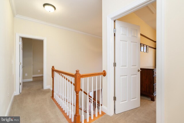 hallway with light carpet, ornamental molding, an upstairs landing, and baseboards