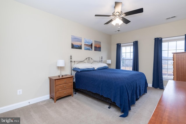 bedroom featuring light carpet, baseboards, visible vents, and a ceiling fan