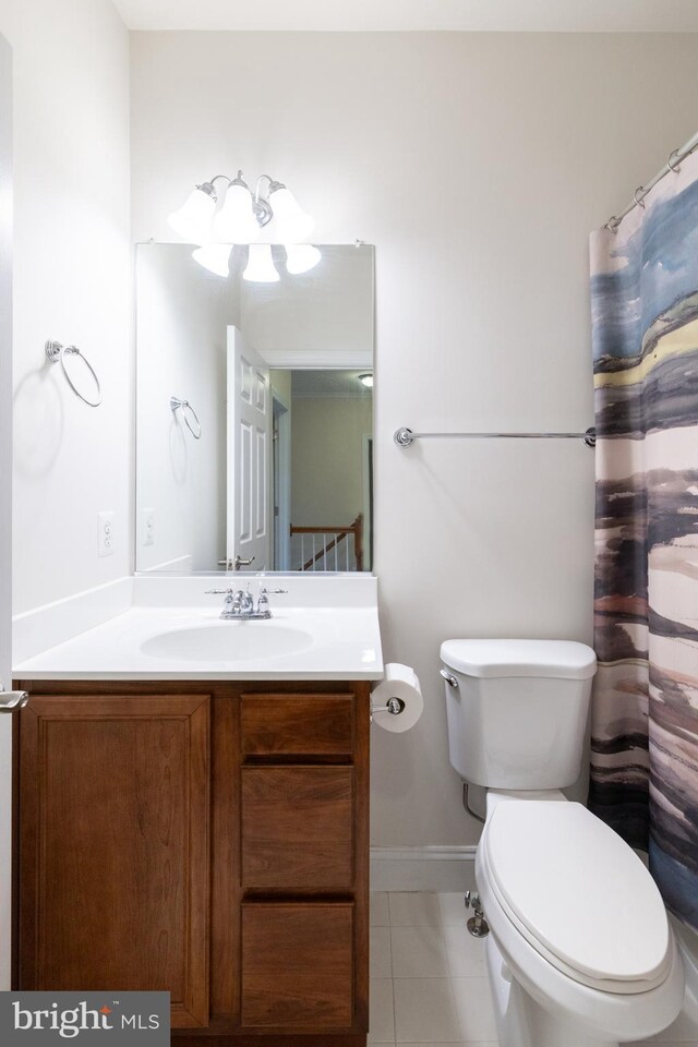 bathroom featuring toilet, tile patterned floors, baseboards, and vanity