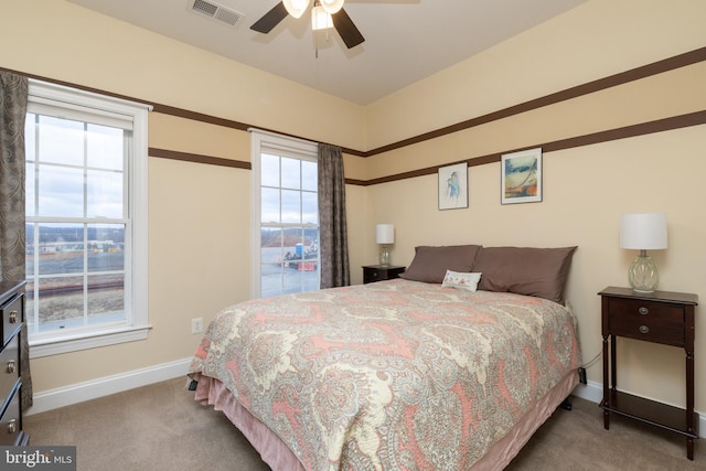 carpeted bedroom with a ceiling fan, visible vents, and baseboards