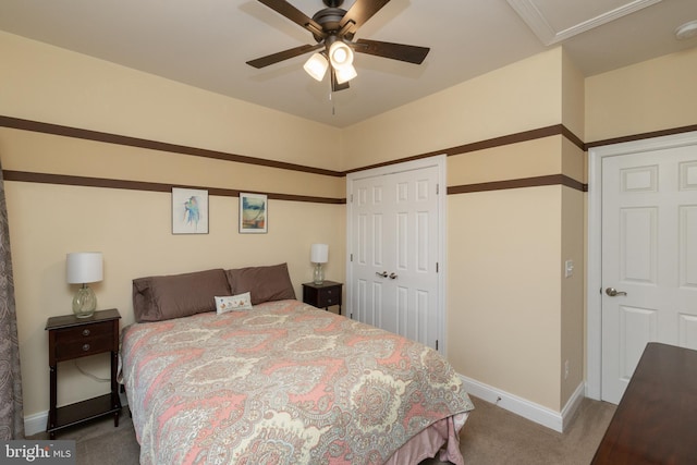 carpeted bedroom featuring a ceiling fan, a closet, and baseboards