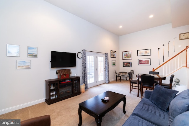 living room featuring recessed lighting, stairs, baseboards, and light colored carpet