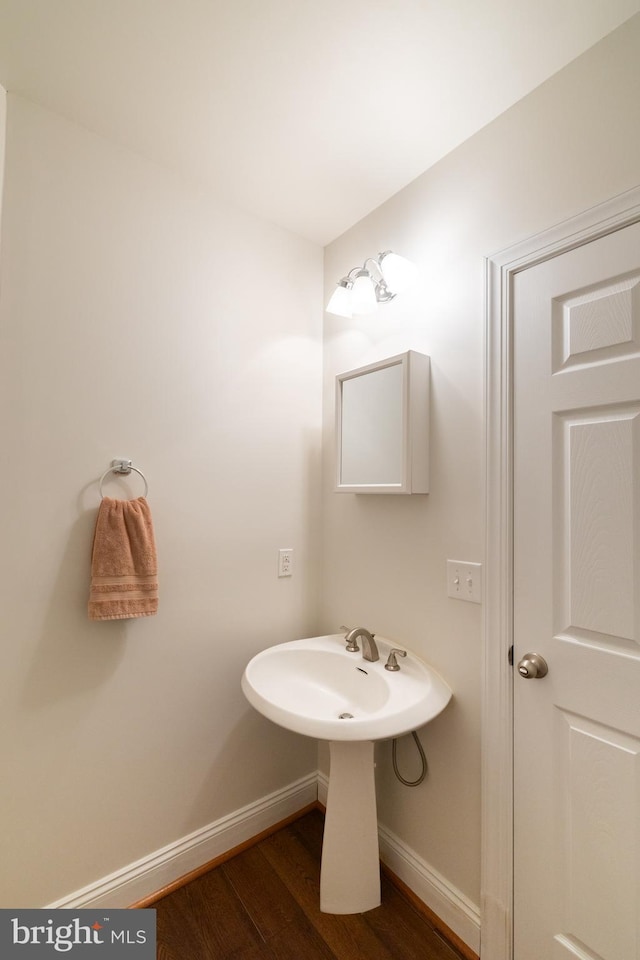 bathroom with baseboards and wood finished floors