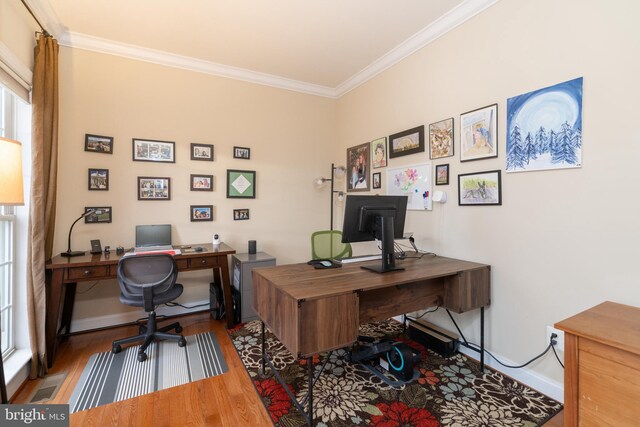 office with ornamental molding, visible vents, baseboards, and wood finished floors