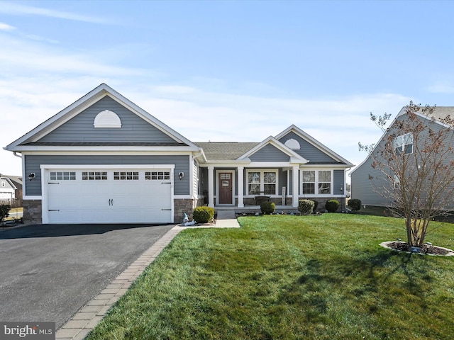 view of front facade featuring stone siding, a front lawn, an attached garage, and driveway