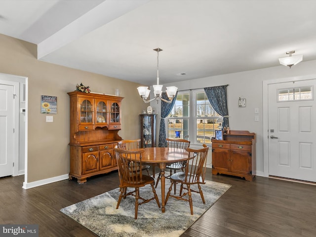 dining space with dark wood-type flooring, baseboards, and a chandelier