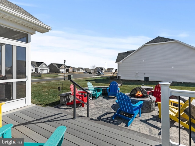 wooden terrace with a residential view, a lawn, and a fire pit