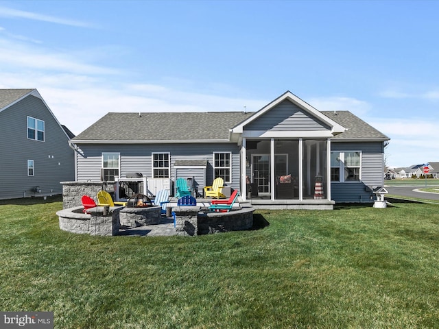 back of house featuring a fire pit, a lawn, a sunroom, and roof with shingles