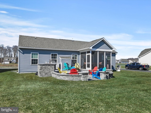 back of house with a yard, an outdoor fire pit, a patio area, and a sunroom